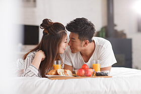 青年情侣在床上吃早餐图片