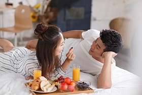 青年情侣在床上吃早餐图片