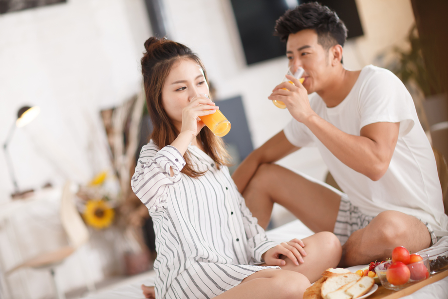 青年情侣在床上吃早餐照片