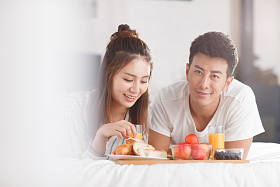 青年情侣在床上吃早餐图片
