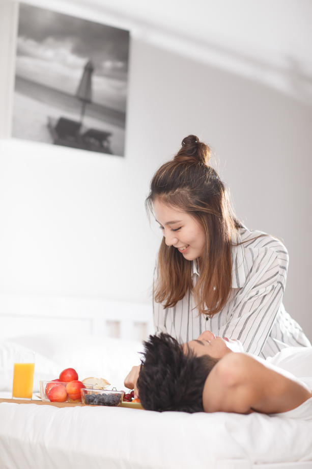 青年情侣在床上吃早餐 青年情侣在床上吃早餐