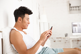 青年男人在卧室玩手机