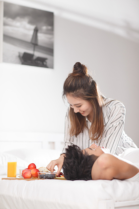 青年情侣在床上吃早餐图片