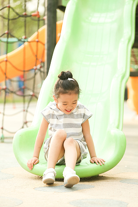 小女孩在户外玩滑梯