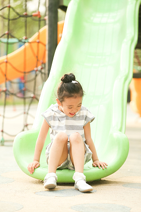 小女孩在户外玩滑梯