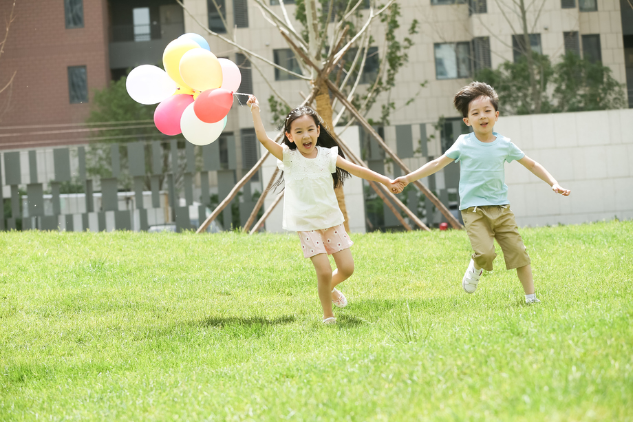 快乐儿童在草地上玩耍照片