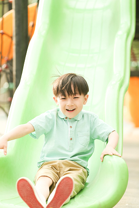 小男孩在户外玩滑梯