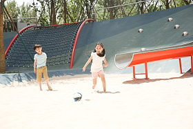 儿童在沙子里踢球图片