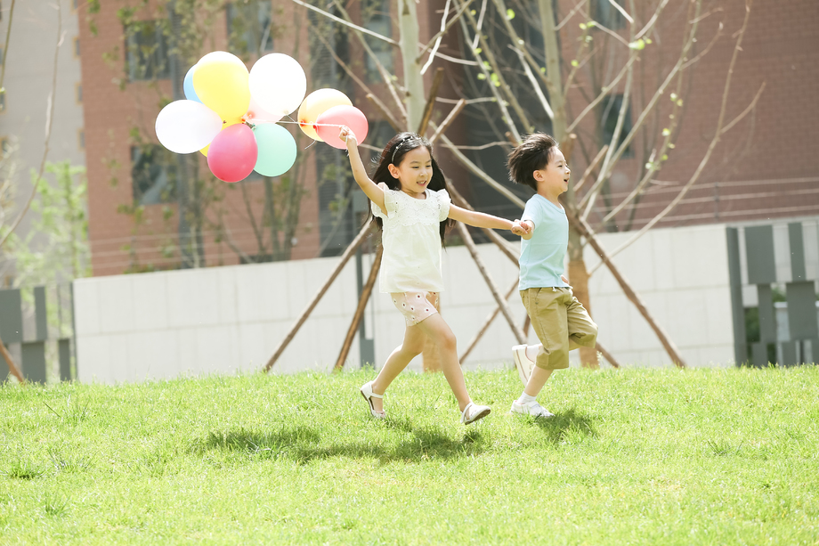 快乐儿童在草地上玩耍照片