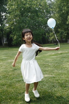 可爱的小女孩在户外玩耍照片