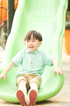 小男孩在户外玩滑梯图片