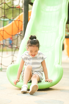 小女孩在户外玩滑梯