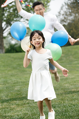 父亲陪着女儿在户外玩耍