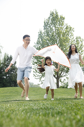 一家三口在草地上放风筝照片