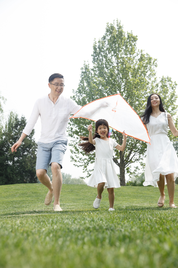 一家三口在草地上放风筝照片