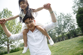 父亲驮着女儿在户外玩耍