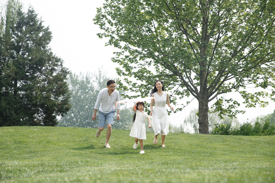 一家三口在草地上放风筝