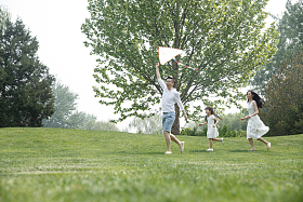 一家三口在草地上放风筝图片