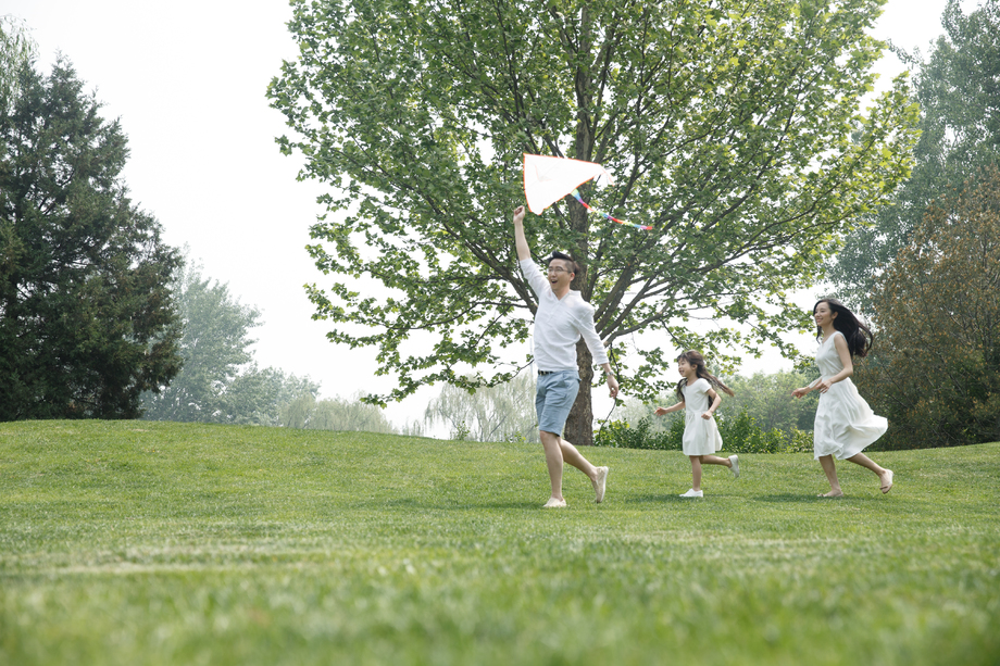 一家三口在草地上放风筝图片
