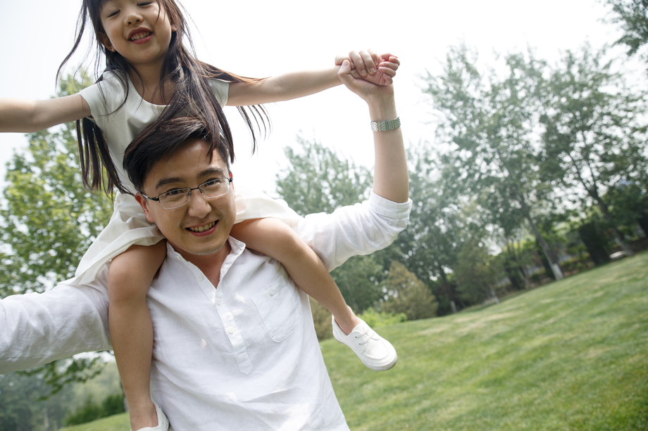 父亲驮着女儿在户外玩耍 父亲驮着女儿在户外玩耍