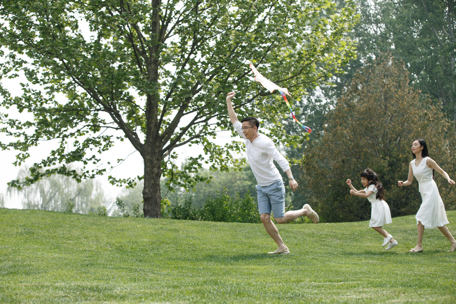 一家三口在草地上放风筝图片