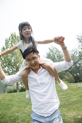 父亲驮着女儿在户外玩耍图片