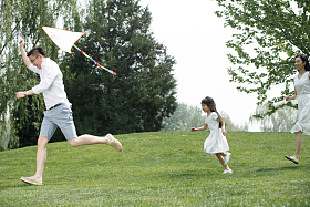 一家三口在草地上放风筝图片