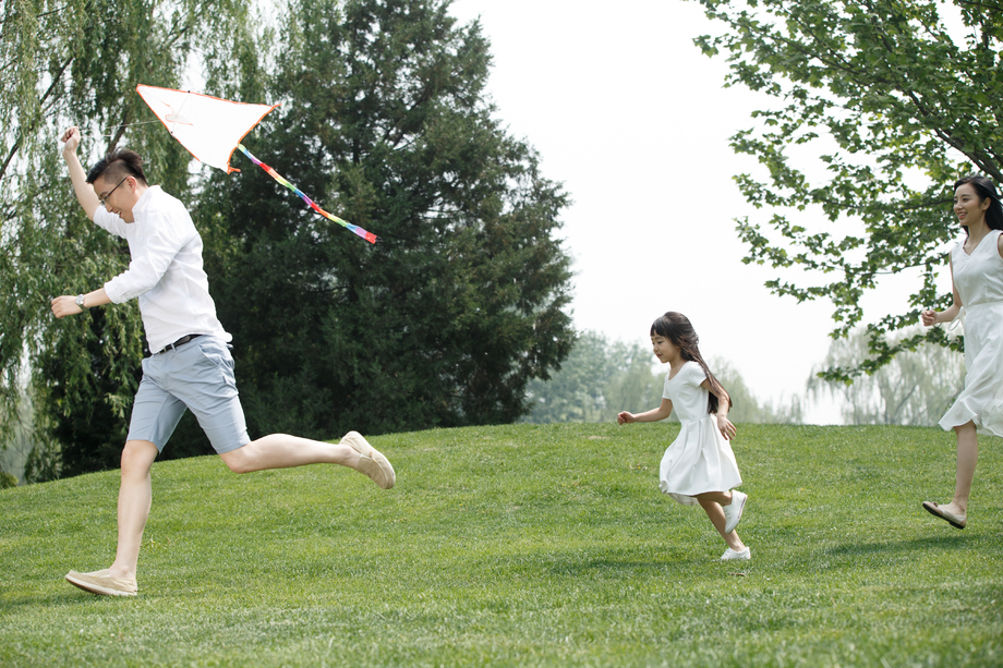 一家三口在草地上放风筝图片