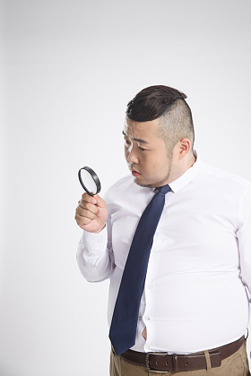商务男士拿着放大镜