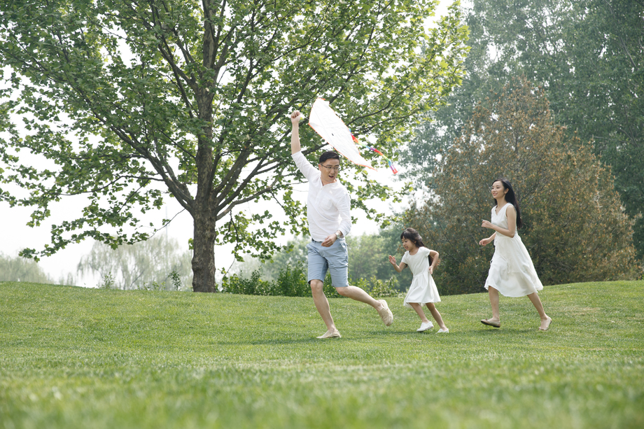 一家三口在草地上放风筝图片