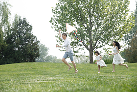 一家三口在草地上放风筝图片