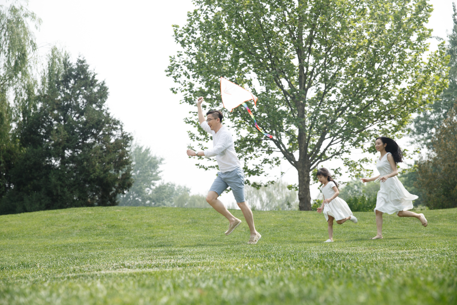 一家三口在草地上放风筝图片