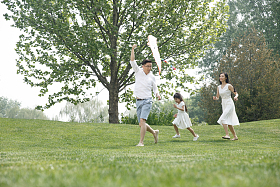 一家三口在草地上放风筝图片