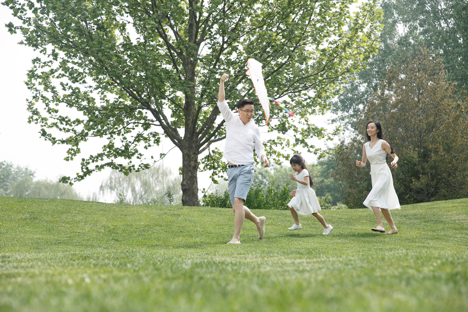 一家三口在草地上放风筝图片