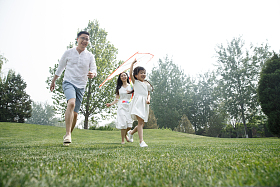 一家三口在草地上放风筝照片