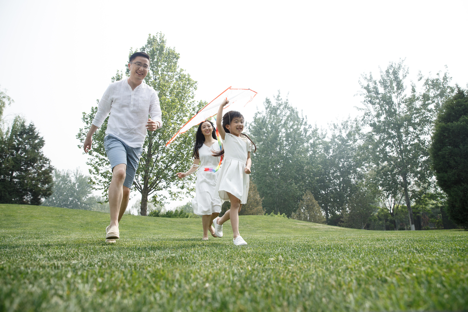 一家三口在草地上放风筝照片