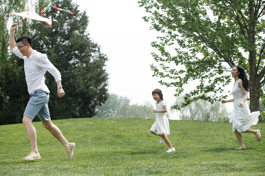 一家三口在草地上放风筝图片
