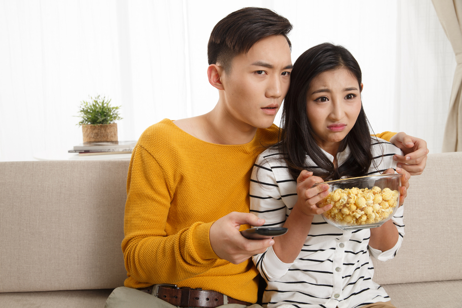 青年情侣坐着沙发上看电视 青年情侣坐着沙发上看电视