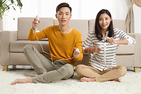 青年情侣坐着沙发上玩游戏图片