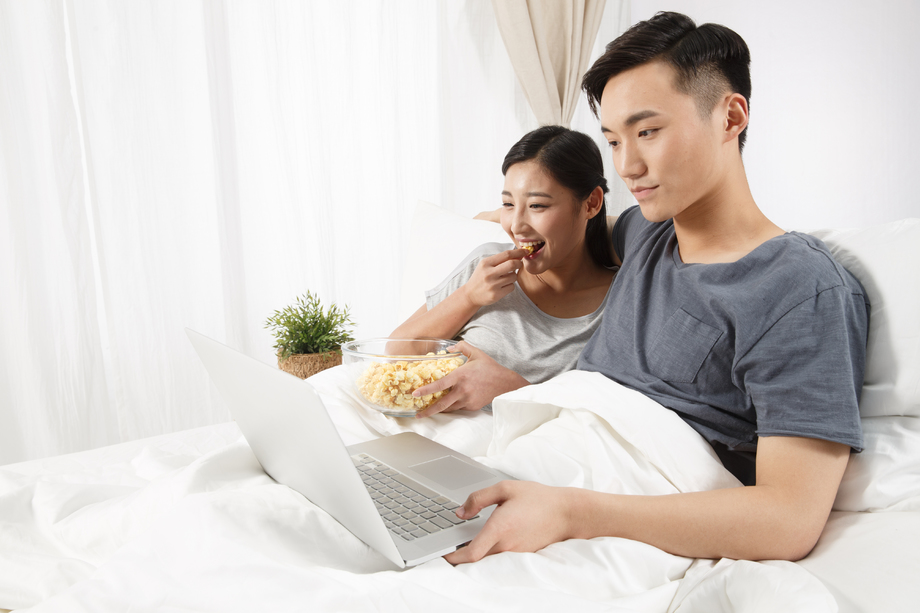 青年情侣坐着床上看电脑图片
