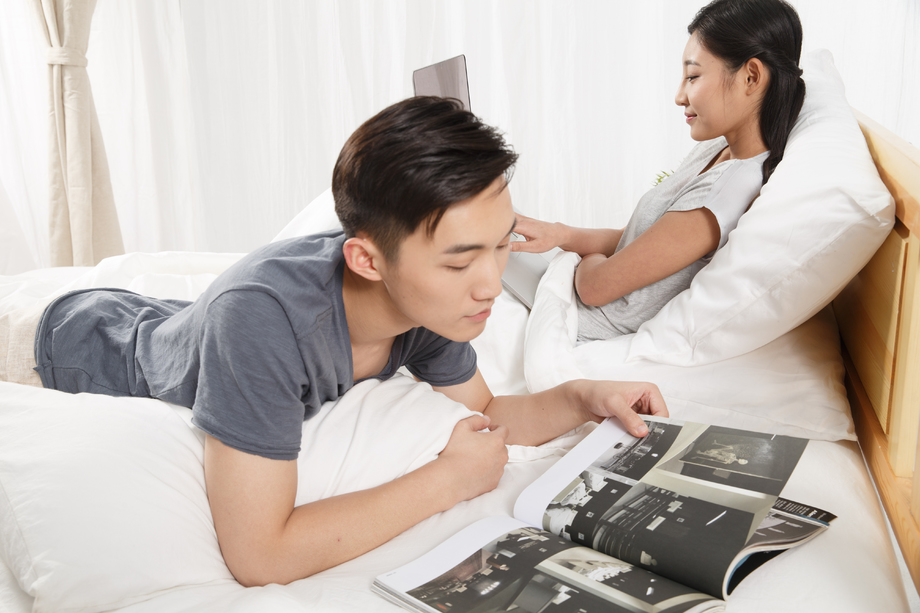 青年男人在床上看书照片
