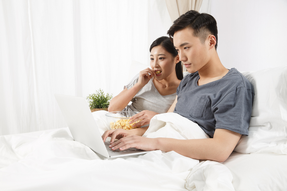 青年情侣坐着床上看电脑图片 青年情侣坐着床上看电脑图片