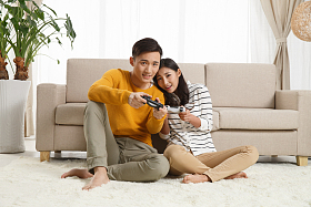 青年情侣坐着沙发上玩游戏图片