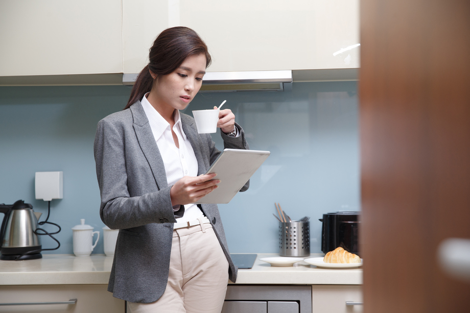 青年女人在厨房使用平板电脑 青年女人在厨房使用平板电脑