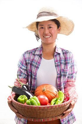 中年女人拿着一筐蔬菜照片
