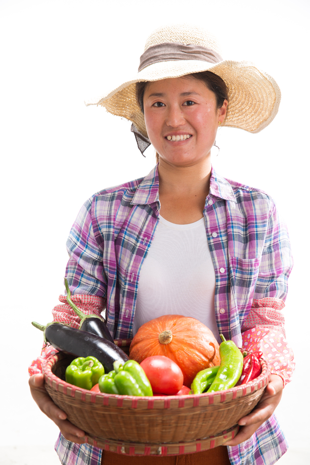 中年女人拿着一筐蔬菜照片