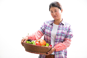 中年女人拿着一筐蔬菜照片