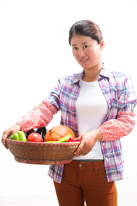 中年女人拿着一筐蔬菜图片