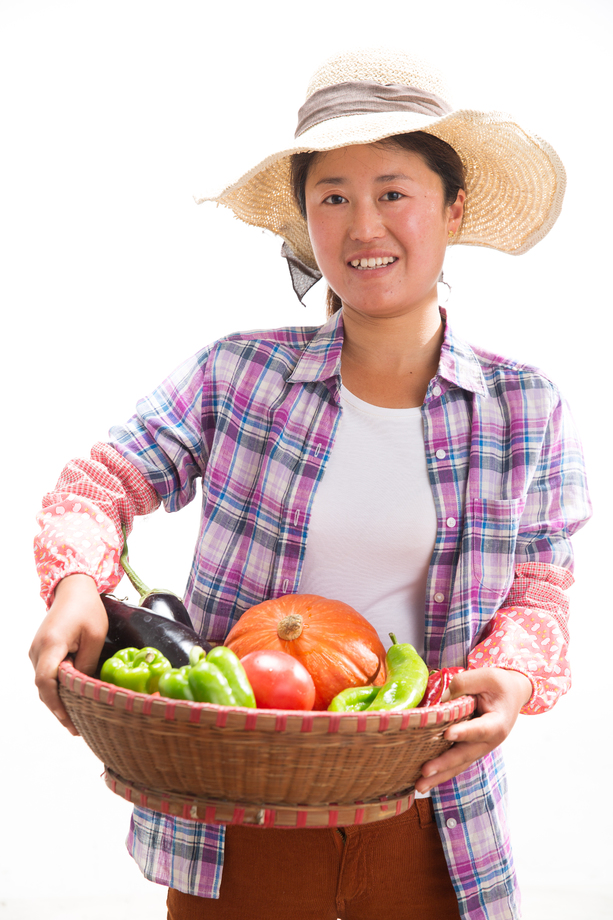中年女人拿着一筐蔬菜
