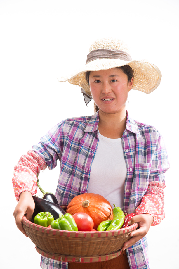 中年女人拿着一筐蔬菜 中年女人拿着一筐蔬菜